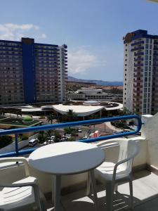 un tavolo e sedie su un balcone con vista sulla città di Amplio apartamento 1 dormitorio - Playa Paraiso a Playa Paraiso