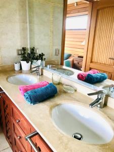 Baño con 2 lavabos y 2 toallas en una encimera en Suite abierta todo el año con vistas al campo, lago y ciudad, en Puerto Varas