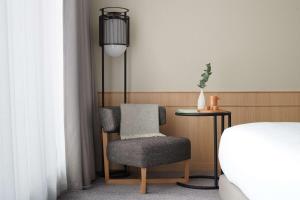 1 dormitorio con silla, mesa y cama en Nobu Hotel London Portman Square, en Londres