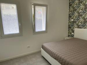 een slaapkamer met een bed en 2 ramen bij Profumo di Mare new 2023 in Alcamo Marina