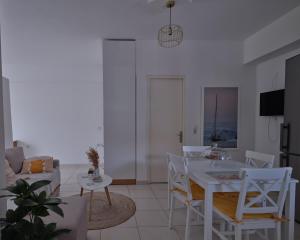 een woonkamer met een witte tafel en stoelen bij comfort apartment in Tripolis