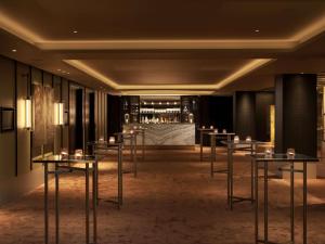 a row of tables in a room with a bar at Nobu Hotel London Portman Square in London