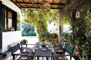 a table and chairs on a patio with an ivy wall at Villa Pigadi Nikiti beach vacation in Metamorfosi