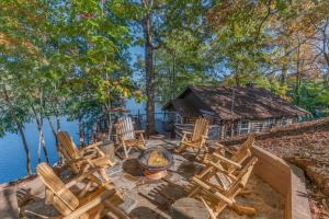 a group of chairs sitting on a patio next to the water at White Oak Point on Lake Lure in Lake Lure
