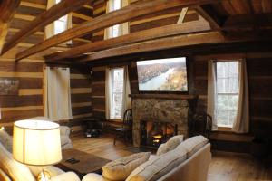 a living room with a fireplace and a tv at White Oak Point on Lake Lure in Lake Lure