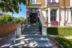ロンドンにあるModern 3 and 2 bedroom flat in central london with full ACの玄関口へ続く階段のある家