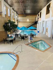 una gran piscina cubierta con mesas y sillas en un edificio en The Suites Hotel at Waterfront Plaza en Duluth