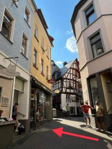 a red arrow is pointing down a street with buildings at Meyver Cochem Centrum. in Cochem