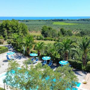uma vista aérea de um resort com mesas azuis e palmeiras em Villa Amica em Vieste
