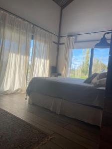 a bedroom with a bed and a large window at Casa de Campo Galpon San Antonio de Areco in San Antonio de Areco