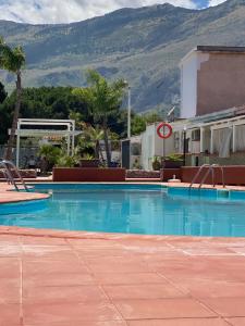 a large swimming pool with a mountain in the background at Cala Holidays vicino Aeroporto&Mare in Carini