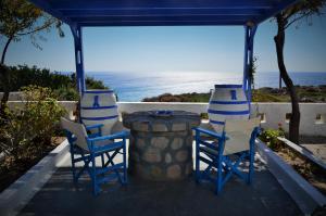 three chairs and a table with the ocean in the background at Summer Residence in Provatas