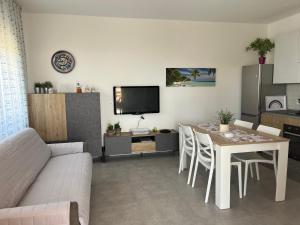 een woonkamer met een bank en een tafel met stoelen bij Profumo di Mare new 2023 in Alcamo Marina