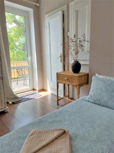 sypialnia z łóżkiem, stołem i oknem w obiekcie Apartamenty NOVA na Krakowskiej No 1 w Bielsku Białej