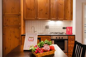 a kitchen with a table with a basket of vegetables at Santa Chiara Apartment by Wonderful Italy in Genova