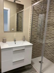 a bathroom with a white sink and a shower at Apartamento Cañebolo in La Puebla de los Infantes +11 photos