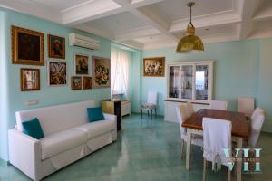 un soggiorno con divano e tavolo di Victory's Luxury House with Jacuzzi on the Roof a Ischia