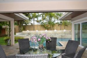 a glass table with chairs and a vase of flowers at 4BRLuxury pool villa near Siam Country club (golf) in Ban Hui Yai Muk