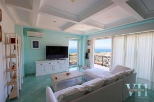 a living room with a couch and a large window at Victory's Luxury House with Jacuzzi on the Roof in Ischia