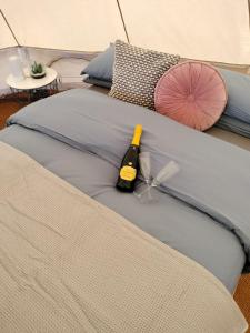 リマバディにあるCarrowmena Family Glamping Site & Activity Centreのベッドの上に座るワイン1本