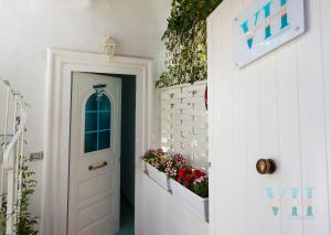 un corridoio con una porta bianca e alcune piante di Victory's Luxury House with Jacuzzi on the Roof a Ischia