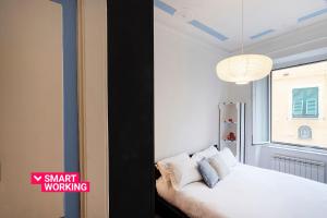 a bedroom with a white bed and a window at Santa Chiara Apartment by Wonderful Italy in Genova