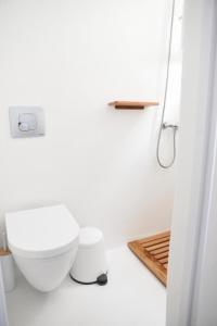 biała łazienka z toaletą i prysznicem w obiekcie Mykonos down town w mieście Mykonos