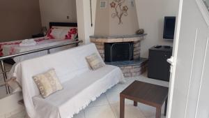 a living room with a couch and a fireplace at Elena in Artemida