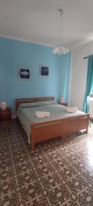 1 dormitorio con cama y pared azul en Mom's House Casa Caterina, en Santa Caterina