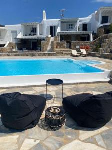een zwembad met twee zitzakken en een tafel en stoelen bij Villa Anna in Elia Beach
