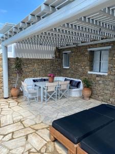 een patio met een tafel en een witte pergola bij Villa Anna in Elia Beach