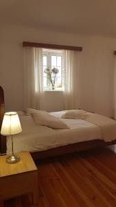 a large bed in a bedroom with a window at Casa Luciana in Ponta do Pargo