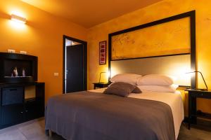 a bedroom with a large bed and a flat screen tv at Oasi Degli Dei in Ranco