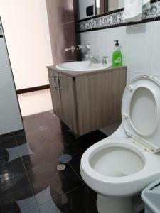 a bathroom with a white toilet and a sink at Moderno apartamento para huespedes in Ipiales