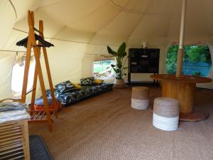 pokój z namiotem z kanapą i stołkami w obiekcie Oasi Degli Dei w mieście Ranco