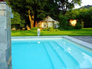 een zwembad in een tuin met een tuinhuisje bij Oasi Degli Dei in Ranco