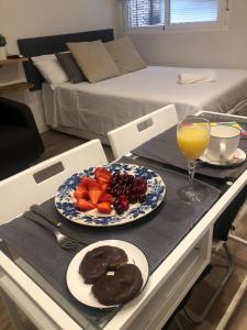 a table with a plate of fruit and a glass of orange juice at Lagasca Charming Apartment in Madrid