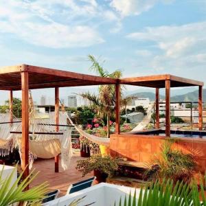 a patio with hammocks and a deck with plants at Apartaestudios Casa Bugambilia in Santa Marta