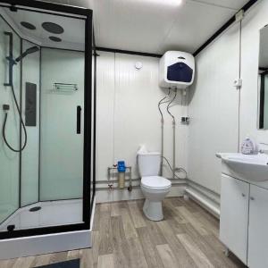 ein Bad mit einer Dusche, einem WC und einem Waschbecken in der Unterkunft Greenery Kupolai 