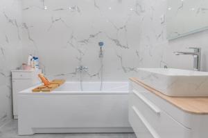 a white bathroom with a tub and a sink at Apartman Anastazije Deluxe in Solin +30 photos