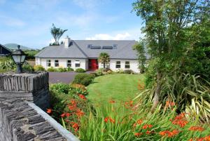 a house with a garden with flowers in front of it at Cúl Draíochta B&B in Cahersiveen