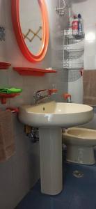 uma casa de banho com um lavatório branco e um WC. em Casa caretta caretta em Manfredónia