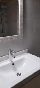 W łazience znajduje się biała umywalka i lustro. w obiekcie Paradise, Porto Saler ET7104 w mieście La Savina
