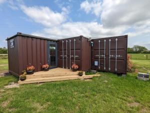 two shipping containers in a yard with a deck at Myrtle in Badsey