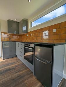 a kitchen with stainless steel appliances and a window at Myrtle in Badsey