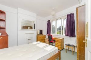 sypialnia z łóżkiem, biurkiem i oknem w obiekcie Lynton Road w Londynie