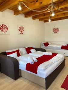 1 dormitorio con 2 camas con sábanas rojas y blancas en SZÍVES LAK 