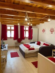 a bedroom with a large bed and red curtains at SZÍVES LAK 