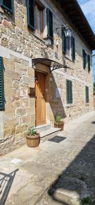 a stone building with a wooden door and a porch at Casa Lichio in Stia