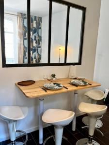 een kamer met een tafel met krukken en een spiegel bij Studio de la Maison de la Plage à 150 m de la plage " Chez Anne à la plage" in Trouville-sur-Mer